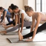 Group of women practicing yoga lesson, doing Ardha Hanumanasana exercise