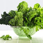 Different types of green vegetables in a stainless colander