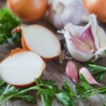 Garlic, onion and shallots on wooden board.