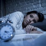 woman in bed late night trying to sleep suffering insomnia