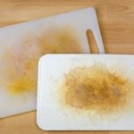 Dirty white plastic cutting board with dark stains, scratch