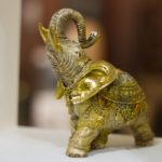 Bronze figure of an elephant with a raised trunk in the interior of a yoga studio, selective focus